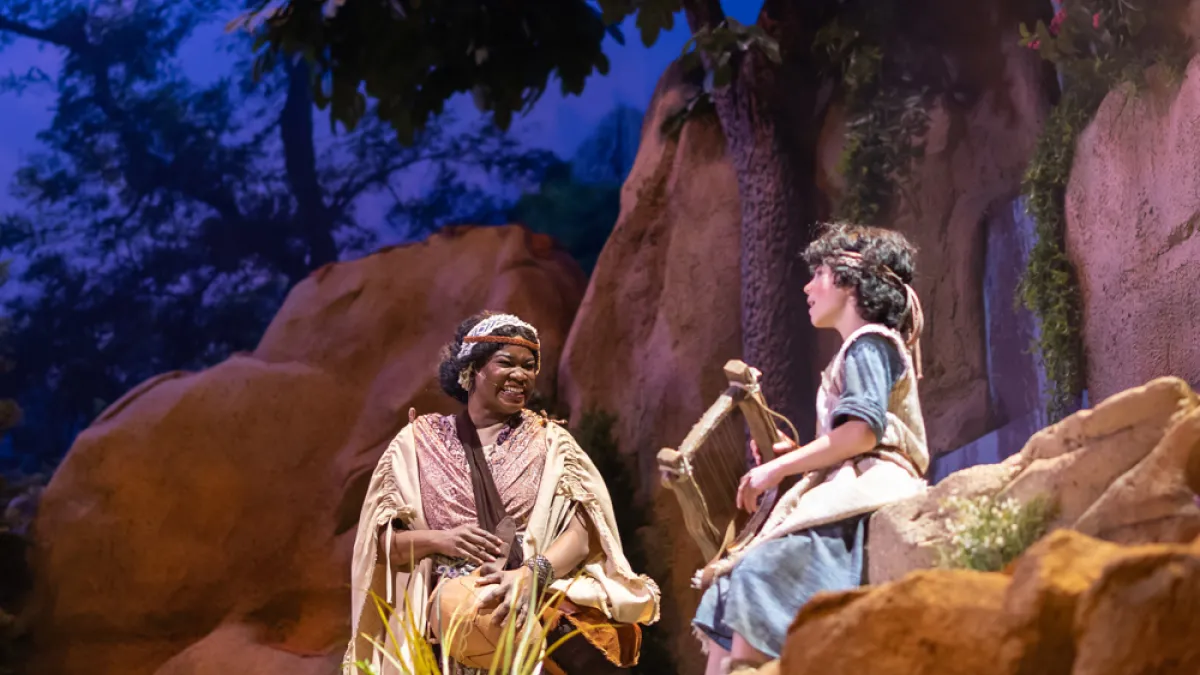 A production photo from DAVID showing a shepherd boy and a woman on a rocky set