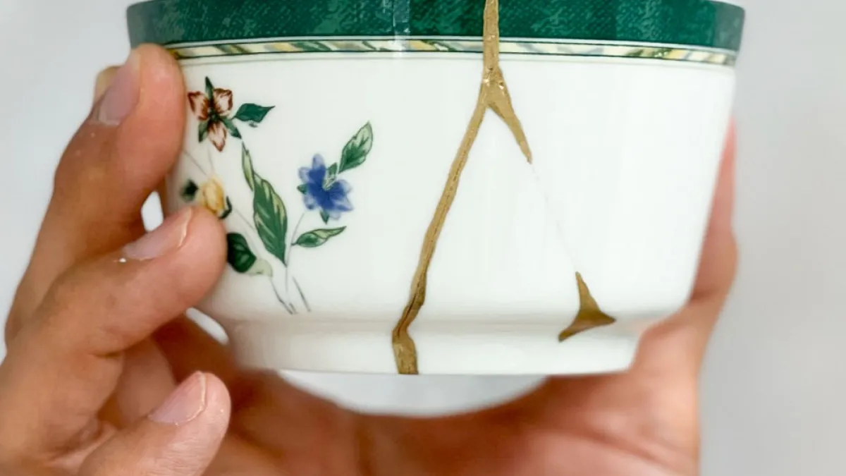 A broken white with floral decoration cup mended with gold
