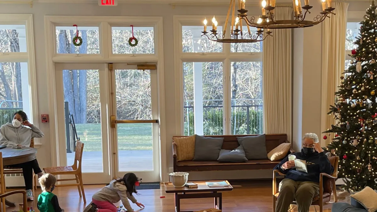 Children and adults spend time near the Christmas tree at Trinity Retreat Center