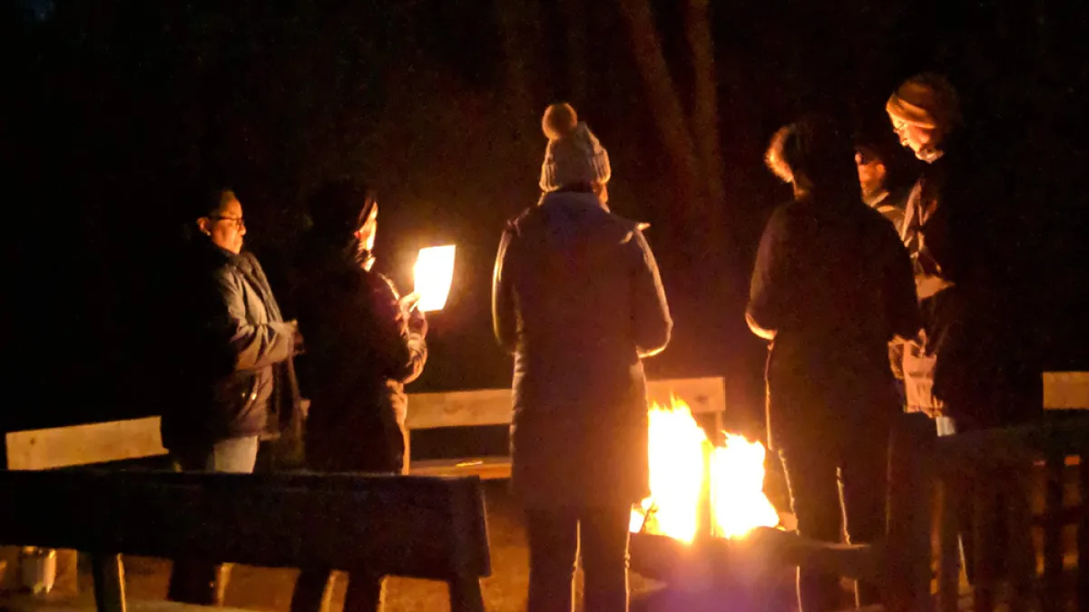 Retreatants gathered around a campfire