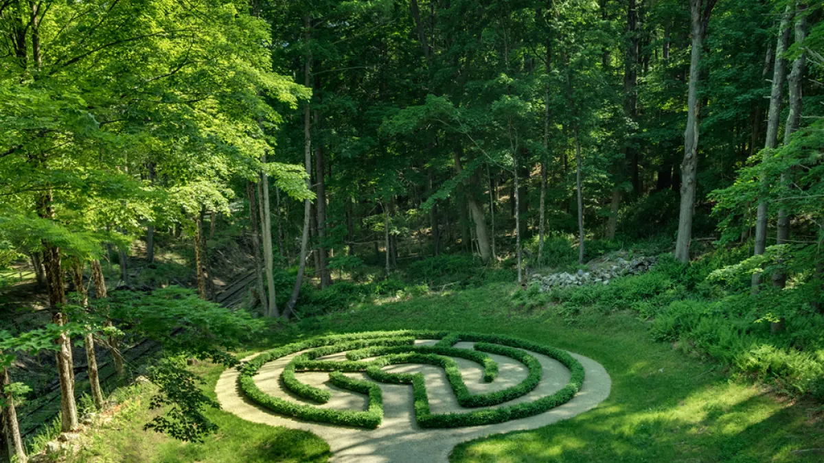 A green forest around a garden labyrinth at the Trinity Retreat Center