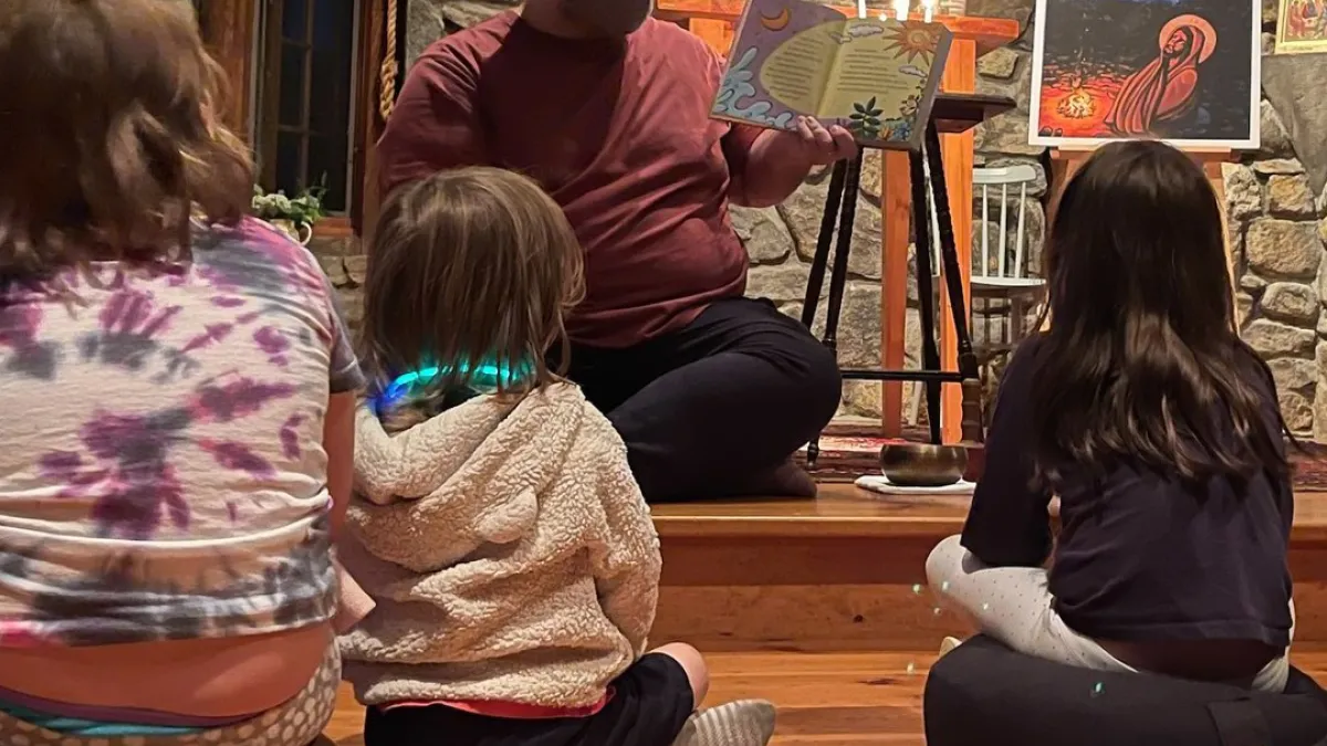 Father Matt reads a book to children in the TRC chapel