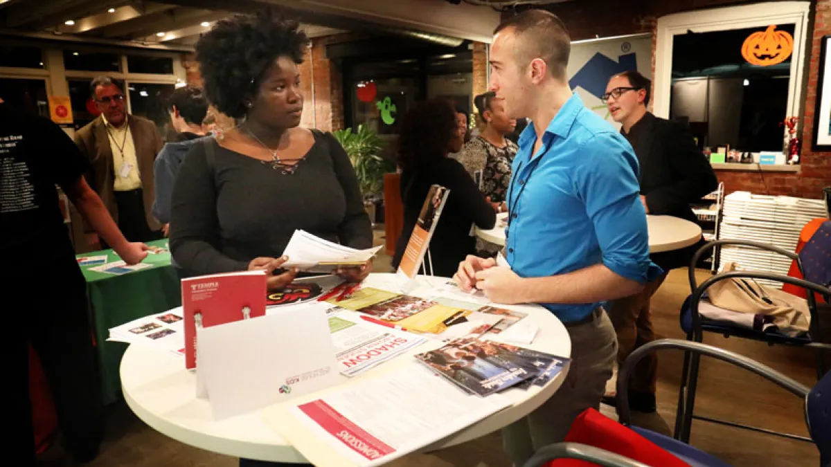 Two people stand at a table