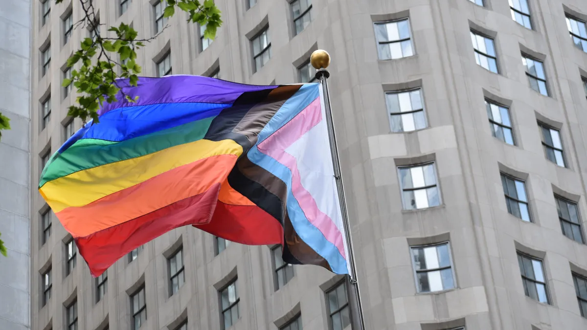 Pride flag with the building in the background