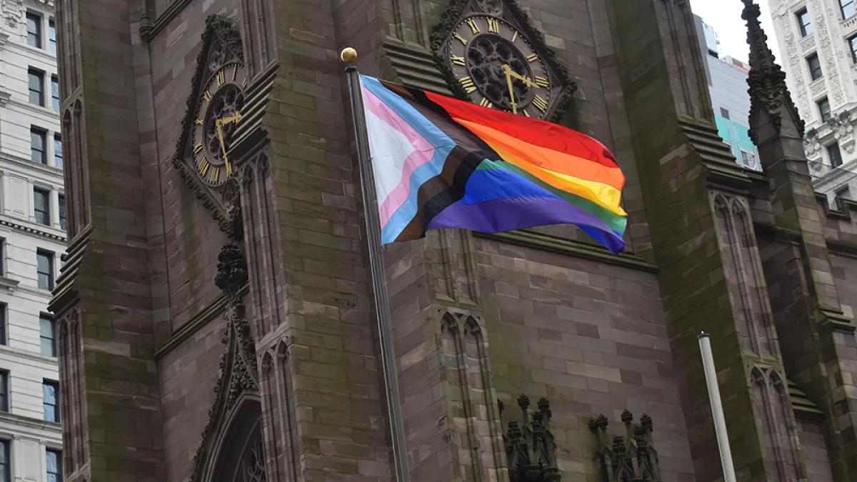 The Progress Pride Flag flies in front of Trinity Church Wall Street