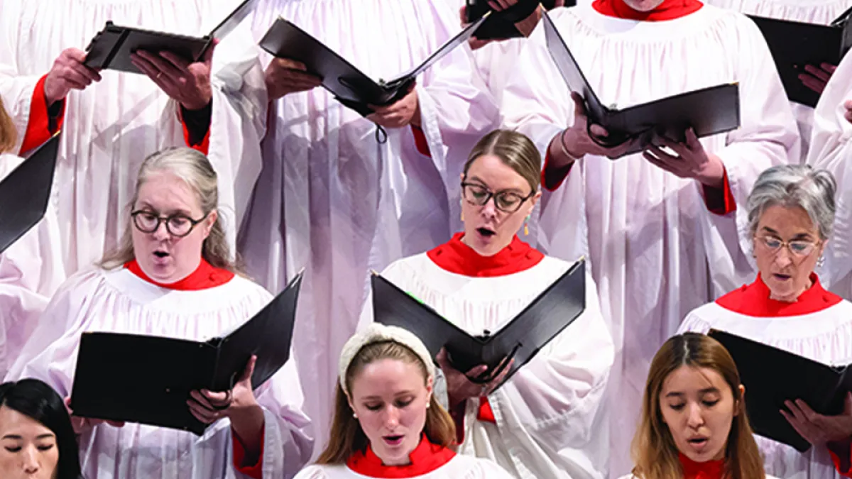 Several choir members in robes sing