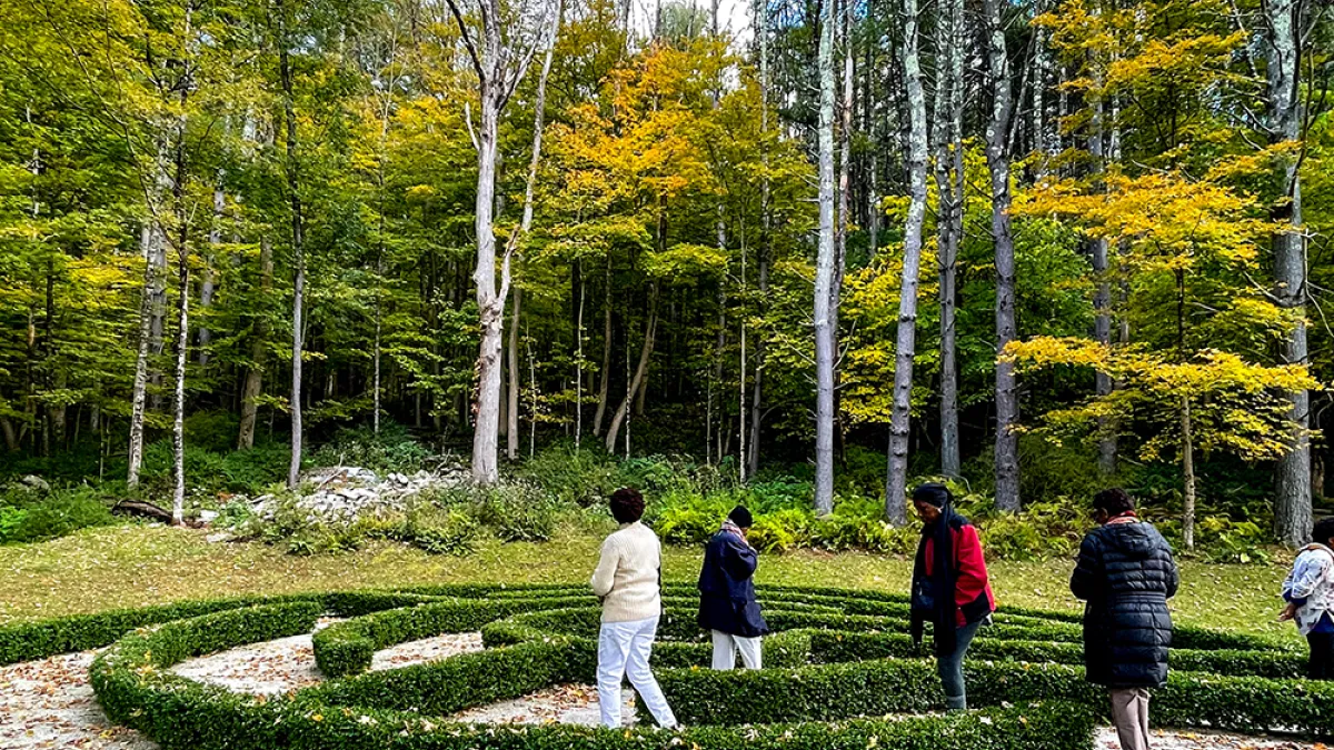 People walk in the hedge maze at the Trinity Retreat Center