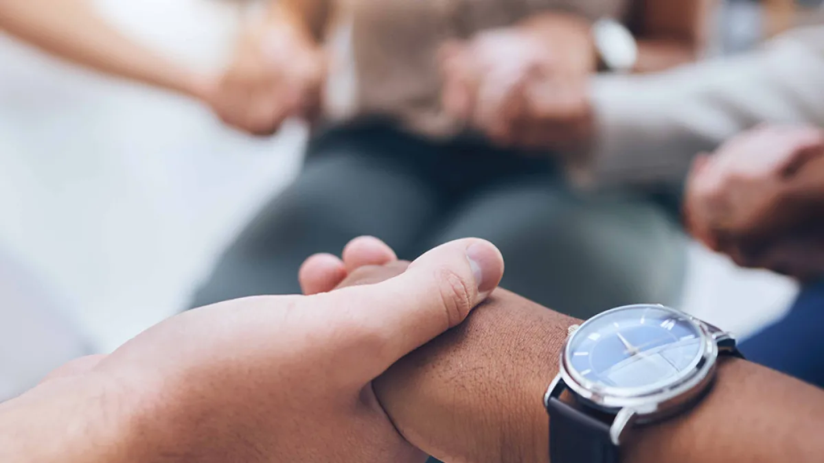 People holding hands in a support group