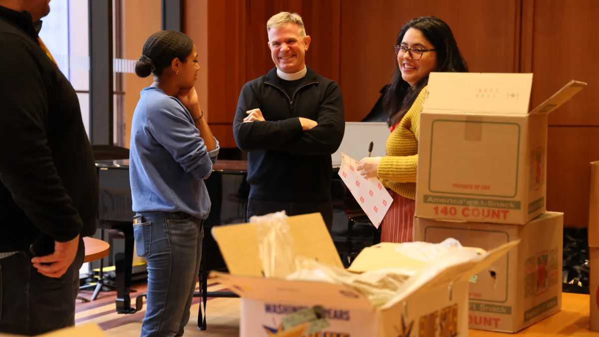 The Vicar and Trinity Outreach staff pack groceries at the Christmas Compassion Market pack.