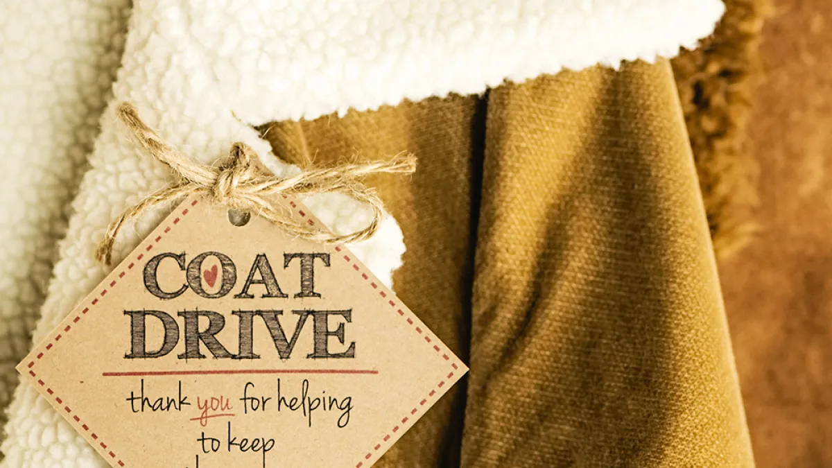 Image of winter coats, with a tag reading: COAT DRIVE - thank you for helping to keep others warm