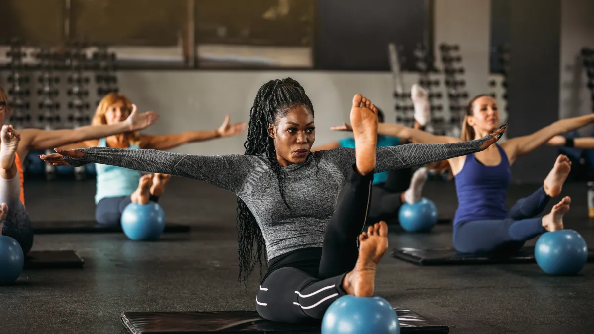 Women of various ages and races engage in a mat pilates class.