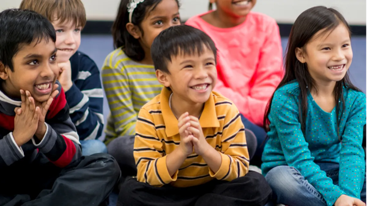 School age kids sit together on the floor 