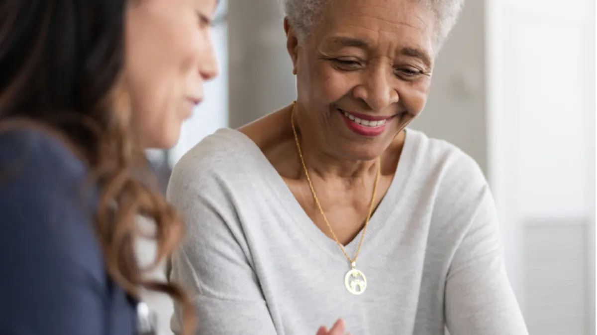 A lady teaches a senior woman about smartphone 