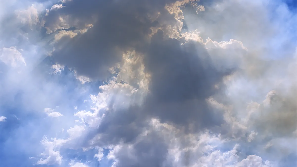 Image of sunlight behind a cloud against a blue sky