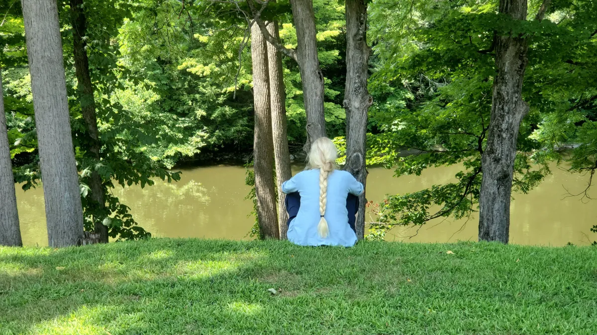 Woman sitting by river