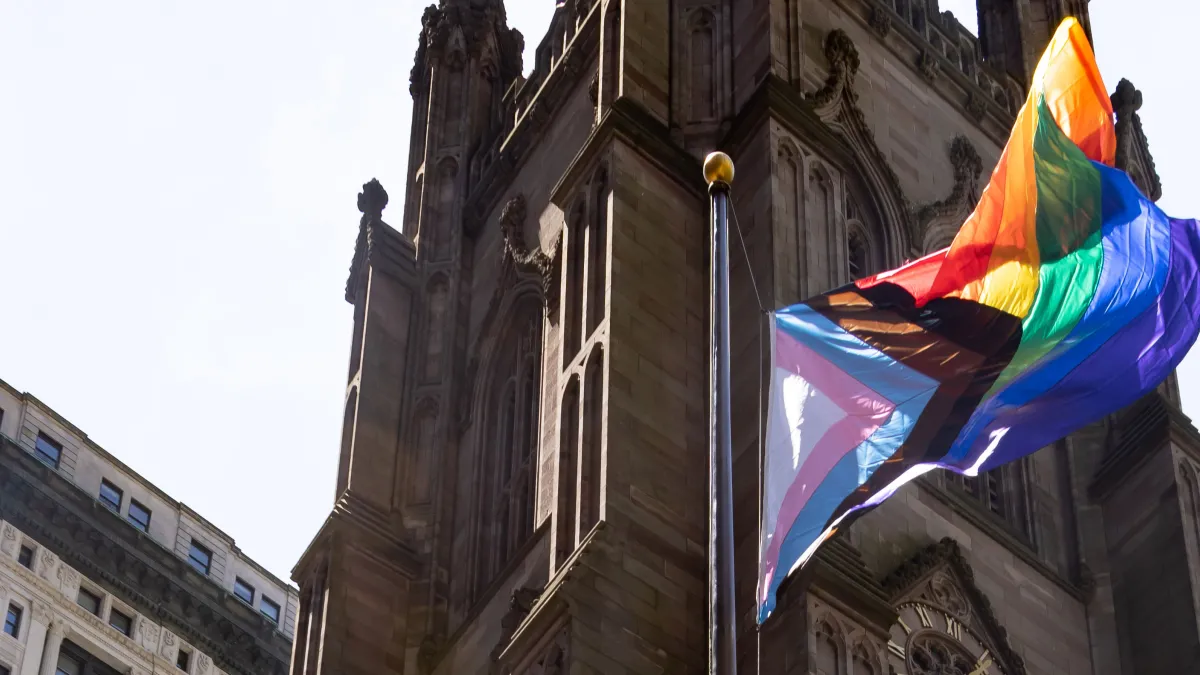 The pride flag with the church in the background. 