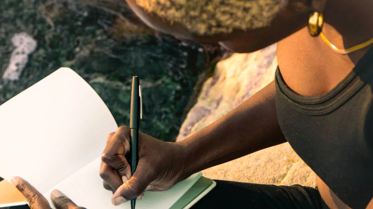 A person writes on a journal