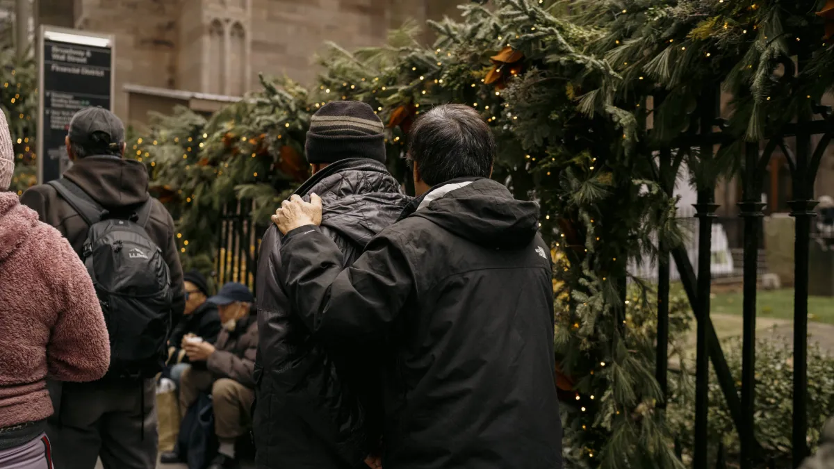 People wait in line for Christmas groceries distribution in front of Trinity Church.