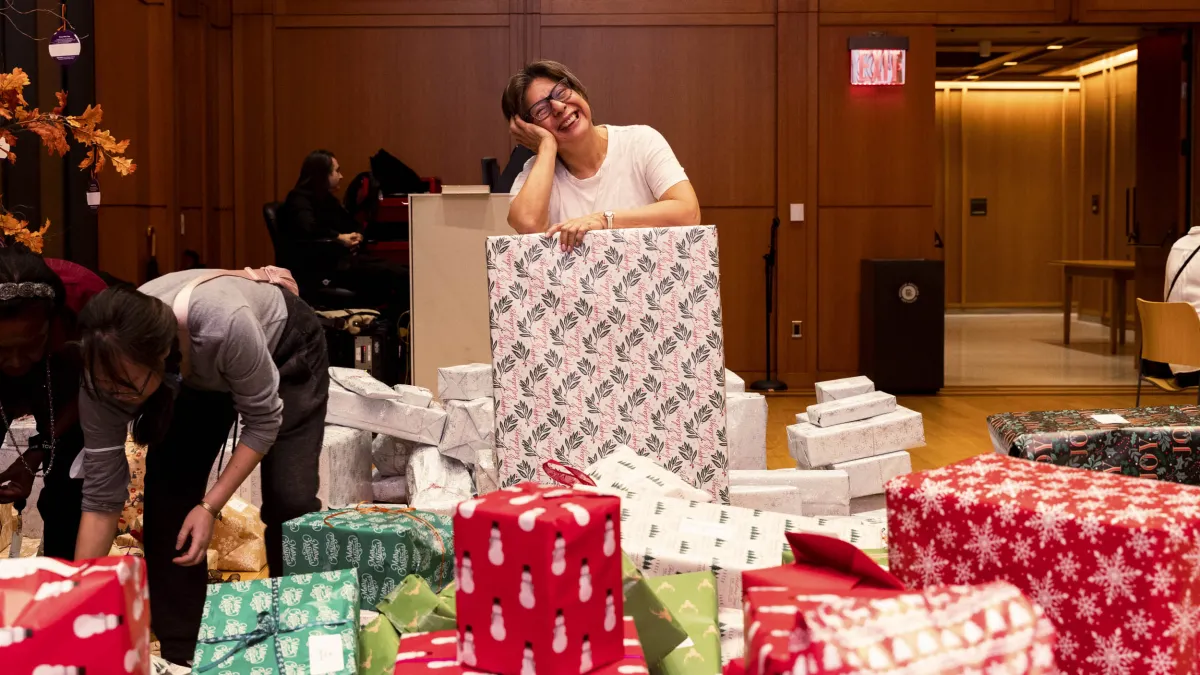 A person is making a pose on top of a wrapped gift.