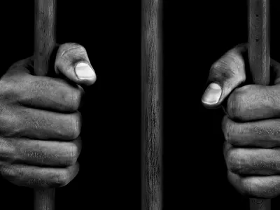 hands clenching bars