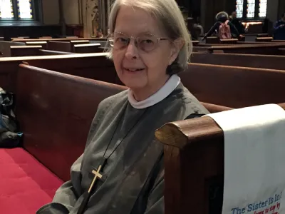 Sister Ann Whittaker sits in a pew at Trinity Church