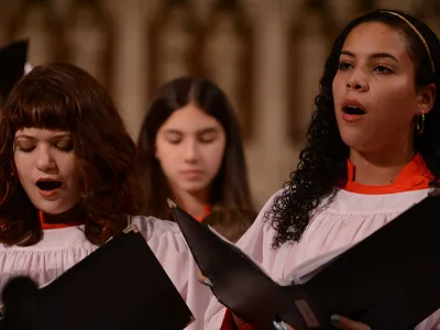 Trinity Youth Chorus members sing in white and red robes at Trinity Church