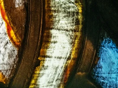 A close-up of a blue, yellow, orange, and white section of stained glass in the Chapel of All Saints at Trinity Church Wall Street