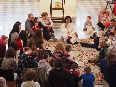 The Rev. Winnie Varghese sits on the carpet during a sermon at the 9:15 Family Service in St. Paul's Chapel, surrounded by families.