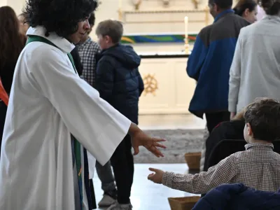 The Rev. Winnie Varghese greets a child during a family service at St. Paul's Chapel