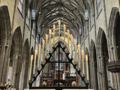 Tenebrae hearse candleholder arranged in a triangle, with 15 taper candles and the nave of Trinity Church in the background.