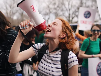 Parishioner Azaelia Danes at Climate March with a megaphone