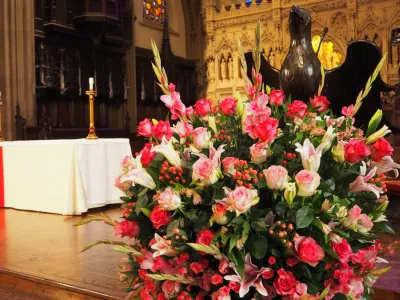 Bright pink flowers in front of the Trinity Church altar with the Lenten linen on it