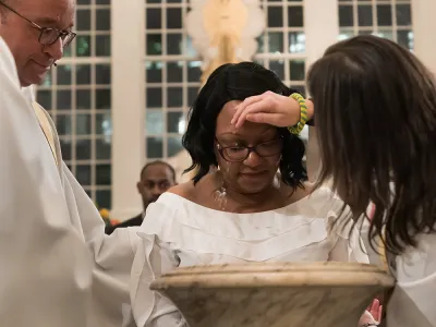 Priest baptizing woman