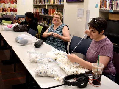 Trinity Knitters smiling and working in the Parish Center