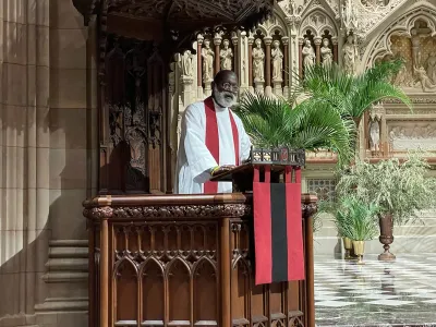 The Rev. Dr. Mark Bozzuti-Jones preaches on Maundy Thursday at Trinity Church with palms in the background.