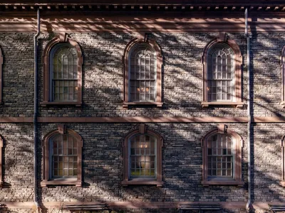 An exterior wall of St. Paul's Chapel covered in the shadow of a tree