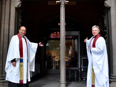 Phil Jackson and Michael Bird welcome parishioners back to Trinity Church.