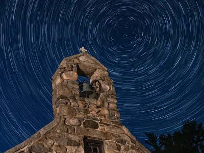 A long exposure image of a star-filled sky above the chapel at Trinity Retreat Center