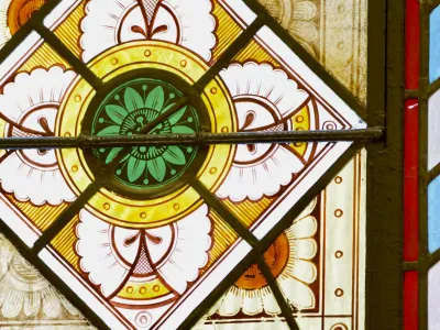 A close-up of a stained glass window in Trinity Church with green and white flowers over a yellow, red, blue, and white background