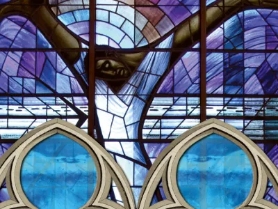 Stained glass image of man with arms outstretched