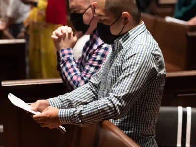 Worshippers kneeling in the pews of Trinity Church
