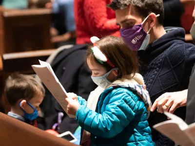 A family looks through the worship bulletin together in Trinity Church