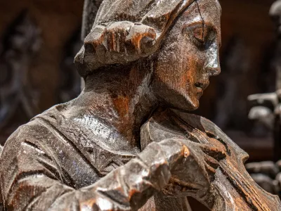 A wooden carving of an angel playing an instrument