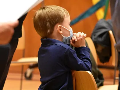 A child prays during Family Service in Parish Hall