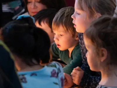 Children gather in glowing candlelight