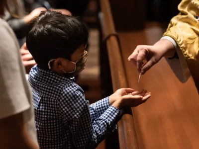 A child receives a communion wafer in Trinity Church