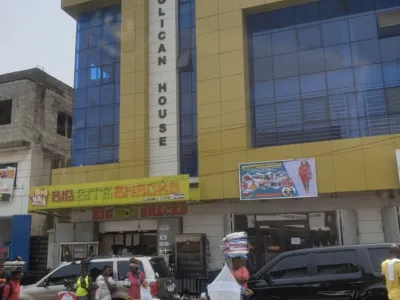 Exterior shot of the Anglican House structure in Freetown, Sierra Leone. People stand outside the building in the foreground.