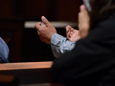 A person lifts up their hands in prayer in Trinity Church