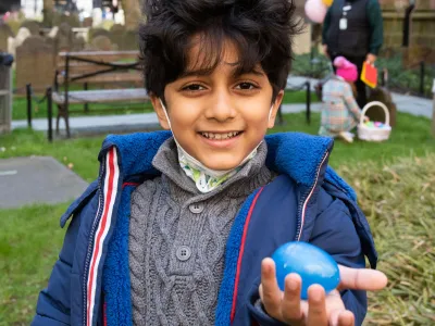 A child finds an Easter egg in Trinity Churchyard on Easter Day