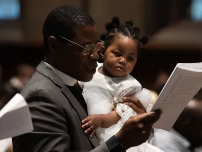 A man holds a child during Holy Eucharist at Trinity Church